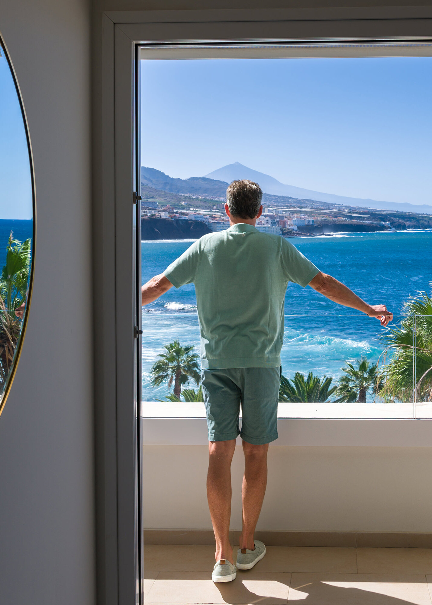 Hotelgast blickt vom Balkon seiner Suite im OCÉANO Health Spa Hotel Teneriffa über den Atlantik, auf den Vulkan El Teide und die Bucht von Punta del Hidalgo
